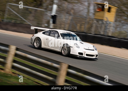 Porsche GT3 accelerando attraverso lodge angolo durante i test ad Oulton Park race circuito. Foto Stock