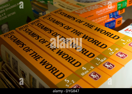 Un assortimento di Stanley gibbons timbro cataloghi sul visualizzatore in corrispondenza di un timbro d'aste, petersfield, hampshire, Regno Unito. Foto Stock