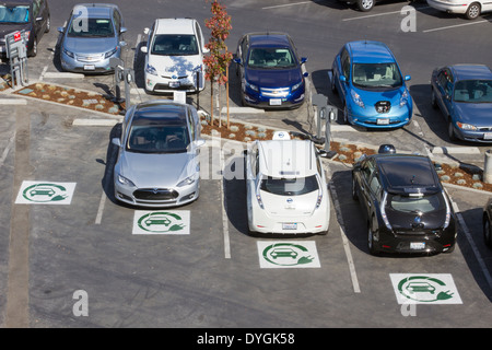 Diversi tipi di plug-in di auto elettriche parcheggiato a EV stazioni di carica in una società di parcheggio Foto Stock