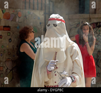 L'uomo vestito di tunica bianca e il cofano portante un diffusore di incenso nella Domenica delle Palme processione durante la Semana Santa, Salamanca, Spagna. Foto Stock