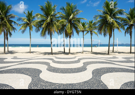 Curvatura iconica marciapiede tile pattern con palme sulla spiaggia di Copacabana a Rio de Janeiro in Brasile Foto Stock