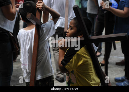 Quezon City, Filippine. Xvii Apr, 2014. QUEZON Quezon City, Filippine - I cattolici filippini portano croci di legno come essi prendono parte alle Stazioni della Croce all'interno di una cappella in Quezon City, a nord-est di Manila il Giovedì Santo, 17 aprile 2014. Molti devoti contrassegnare la Settimana Santa da sottoposto a diverse forme di penitenza fisica nella convinzione che questi si esime dai loro peccati. Credito: George Calvelo/NurPhoto/ZUMAPRESS.com/Alamy Live News Foto Stock