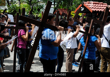 Quezon City, Filippine. Xvii Apr, 2014. QUEZON Quezon City, Filippine - I cattolici filippini portano croci di legno come essi prendono parte alle Stazioni della Croce all'interno di una cappella in Quezon City, a nord-est di Manila il Giovedì Santo, 17 aprile 2014. Molti devoti contrassegnare la Settimana Santa da sottoposto a diverse forme di penitenza fisica nella convinzione che questi si esime dai loro peccati. Credito: George Calvelo/NurPhoto/ZUMAPRESS.com/Alamy Live News Foto Stock