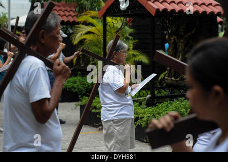 Quezon City, Filippine. Xvii Apr, 2014. QUEZON Quezon City, Filippine - I cattolici filippini portano croci di legno come essi prendono parte alle Stazioni della Croce all'interno di una cappella in Quezon City, a nord-est di Manila il Giovedì Santo, 17 aprile 2014. Molti devoti contrassegnare la Settimana Santa da sottoposto a diverse forme di penitenza fisica nella convinzione che questi si esime dai loro peccati. Credito: George Calvelo/NurPhoto/ZUMAPRESS.com/Alamy Live News Foto Stock