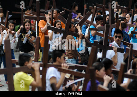 Quezon City, Filippine. Xvii Apr, 2014. QUEZON Quezon City, Filippine - I cattolici filippini portano croci di legno come essi prendono parte alle Stazioni della Croce all'interno di una cappella in Quezon City, a nord-est di Manila il Giovedì Santo, 17 aprile 2014. Molti devoti contrassegnare la Settimana Santa da sottoposto a diverse forme di penitenza fisica nella convinzione che questi si esime dai loro peccati. Credito: George Calvelo/NurPhoto/ZUMAPRESS.com/Alamy Live News Foto Stock