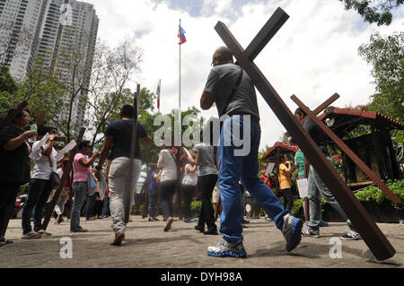 Quezon City, Filippine. Xvii Apr, 2014. QUEZON Quezon City, Filippine - I cattolici filippini portano croci di legno come essi prendono parte alle Stazioni della Croce all'interno di una cappella in Quezon City, a nord-est di Manila il Giovedì Santo, 17 aprile 2014. Molti devoti contrassegnare la Settimana Santa da sottoposto a diverse forme di penitenza fisica nella convinzione che questi si esime dai loro peccati. Credito: George Calvelo/NurPhoto/ZUMAPRESS.com/Alamy Live News Foto Stock