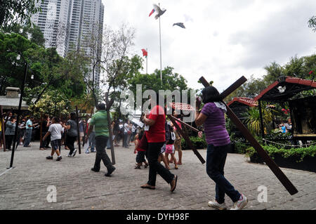 Quezon City, Filippine. Xvii Apr, 2014. QUEZON Quezon City, Filippine - I cattolici filippini portano croci di legno come essi prendono parte alle Stazioni della Croce all'interno di una cappella in Quezon City, a nord-est di Manila il Giovedì Santo, 17 aprile 2014. Molti devoti contrassegnare la Settimana Santa da sottoposto a diverse forme di penitenza fisica nella convinzione che questi si esime dai loro peccati. Credito: George Calvelo/NurPhoto/ZUMAPRESS.com/Alamy Live News Foto Stock