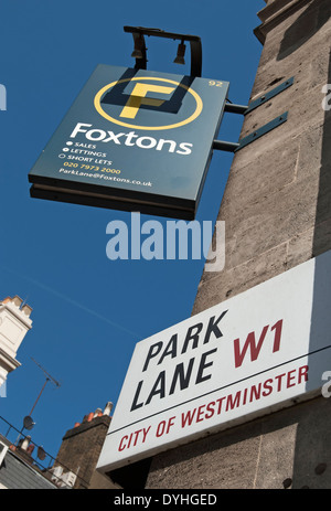 Il nome della strada segno per Park Lane, Londra, Inghilterra sotto appeso un cartello per foxtons agenti immobiliari Foto Stock