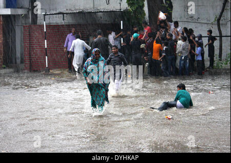 Lahore, Pakistan. Xviii Apr, 2014. Una donna che attraversa una strada allagata durante forti piogge in Pakistan orientale di Lahore, il 18 aprile 2014. Almeno due persone sono state uccise e molti altri feriti in pioggia incidenti correlati nella provincia pakistana del Punjab il venerdì i media locali hanno riferito. Credito: Jamil Ahmed/Xinhua/Alamy Live News Foto Stock