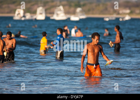 Un pescatore porta e mantiene un pesce ha catturato off Playa Tamarindo Guanacaste Costa Rica Foto Stock