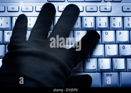 Schwarze mano auf Computertastatur, Datenklau Foto Stock