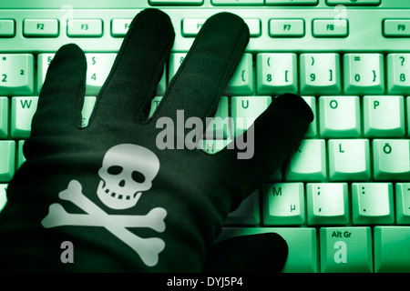 Schwarze mano mit Totenkopf auf Computertastatur, Cyberkriminalität Foto Stock