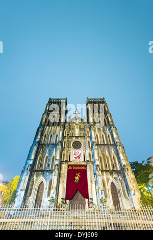 Recintato alto edificio con cielo azzurro e gli alberi in background. La facciata della chiesa antica. Bella San Giuseppe Cattedrale. Foto Stock