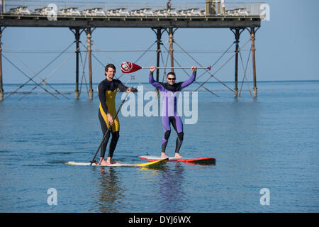 Aberystwyth, Wales, Regno Unito. Il 19 aprile 2014. Due uomini a paddle boards godere il caldo clima soleggiato all inizio del sabato di Pasqua 2014, sguazzare in calma piatta mare di Cardigan Bay off la spiaggia a Aberystwyth sulla West Wales coast. Photo credit: keith morris/Alamy Live News Foto Stock