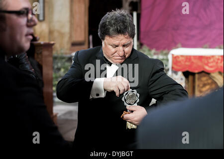 Palermo, Italia. Xviii Apr, 2014. Palermo (Sicilia), 18 apr. 2014 - Un uomo sta per indossare un medaglione che dimostra che il vostro sono devoti a Madre Maria. Centinaia di processioni avvengono in tutta Italia Meridionale durante la pasqua settimana santa. © Guglielmo Mangiapane/NurPhoto/ZUMAPRESS.com/Alamy Live News Foto Stock