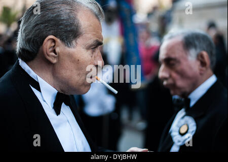 Palermo, Italia. Xviii Apr, 2014. Palermo (Sicilia), 18 apr. 2014 - Un uomo sta fumando una sigaretta in attesa per la processione di passare per le strade di Palermo. Centinaia di processioni avvengono in tutta Italia Meridionale durante la pasqua settimana santa. © Guglielmo Mangiapane/NurPhoto/ZUMAPRESS.com/Alamy Live News Foto Stock