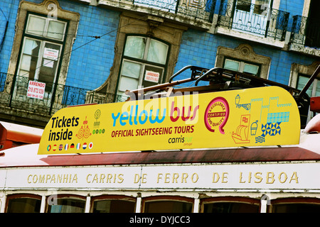 Vintage tram con visite guidate della città annuncio sul passaggio del tetto tradizionale blu vecchio edificio piastrellato in Lisbona Portogallo Europa occidentale. Foto Stock