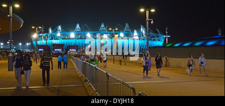 Spettatori delle Olimpiadi a piedi da East London 2012 Paralimpic Games illuminati Evento notturno illuminazione Stadio Olimpico Stratford Newham Londra Inghilterra Regno Unito Foto Stock
