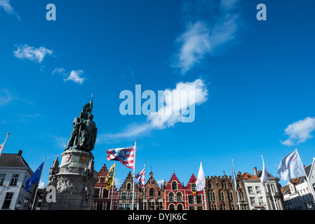 BRUGES, Belgio: Il monumento Jan Breydel e Pieter de Coninck fissa il Markt sullo sfondo di case di corporazione a gradini. Inaugurata nel 1887 con la scultura di Paul De Vigne e un piedistallo in stile neogotico di Louis Delacenserie, la coppia di bronzo commemora due leader fiamminghi la cui resistenza contro il dominio francese culminò nella battaglia degli speroni d'oro l'11 luglio 1302. L'architettura circostante, in gran parte neo-Bruges che storicizzano le ricostruzioni su nuclei medievali, riflette il picco della città come centro commerciale, un'eredità riconosciuta quando il centro storico l'ha conquistata dall'UNESCO Foto Stock