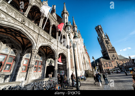 BRUGES, Belgio - edifici decorati nel Markt (Piazza del mercato) nel centro storico di Bruges, un sito patrimonio dell'umanità dell'UNESCO. A sinistra si trova l'edificio Proinial Court. A destra si trova il Belfry. L'architettura medievale e i sereni canali modellano il paesaggio urbano di Bruges, spesso chiamato "la Venezia del Nord". Essendo una città patrimonio dell'umanità dell'UNESCO, Bruges offre ai visitatori un viaggio nel passato dell'Europa, con i suoi edifici ben conservati e le strade acciottolate che riflettono la ricca storia della città. Foto Stock