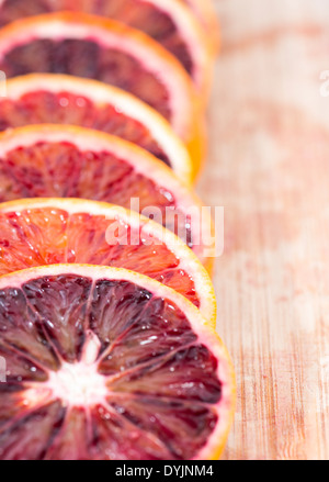 Sangue fresco di arance su sfondo di legno Foto Stock