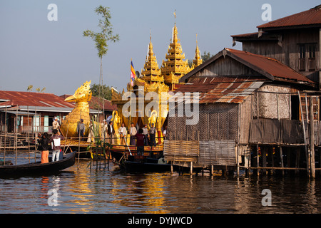 Golden bird barca passando attraverso un lago villaggio durante la Phaung Daw Oo pagoda festival Foto Stock