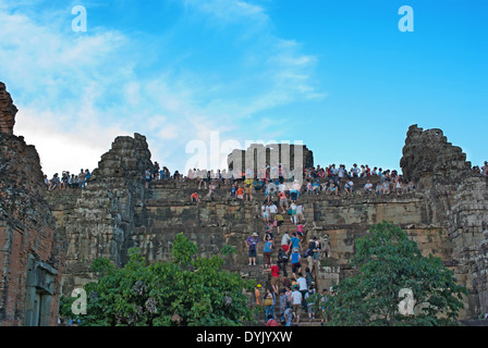 I turisti non identificato la scalata verso la cima di una torre a Angkor Wat per guardare il tramonto. Foto Stock