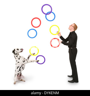 Junger Mann jongliert mit Ringen, giovane giocoleria con anelli, Mann spielt mit Dalmatiner Foto Stock
