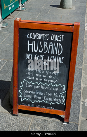 Un comico pub pubblicità segno 'Edinburgh più antichi del marito Day Care Center' presso il White Hart Inn a Grassmarket. Foto Stock