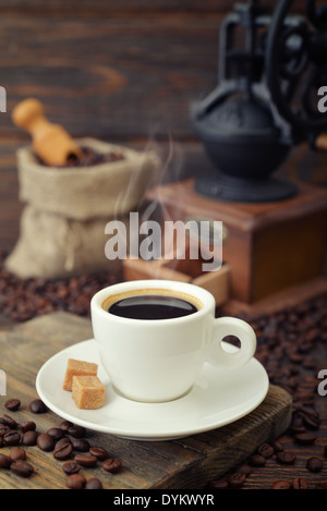 Tazza di caffè espresso caldo con vintage macinino da caffè su sfondo di legno Foto Stock