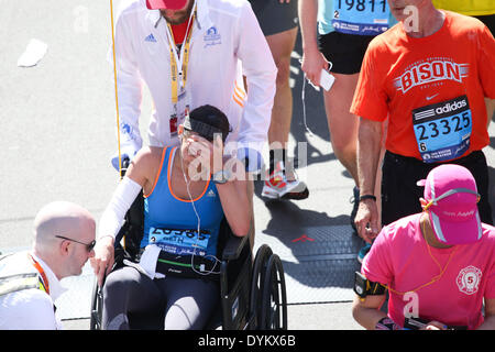 Boston, Massachusetts, USA. Xxi Aprile, 2014. Decine di migliaia di corridori il traguardo del 2014 Maratona di Boston di Boston, Massachusetts. Un ferito runner è aiutato dopo aver attraversato la linea del traguardo. Credito: Nicolaus Czarnecki/METRO Boston/ZUMAPRESS.com/Alamy Live News Foto Stock