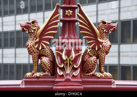 Rosso ornati grifoni, con dettagli prelevato in foglia oro, adornano la lampada vittoriana posti sull'Holborn Viaduct nella città di Londra. Inghilterra, Regno Unito. Foto Stock