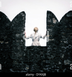 Una signora con un periodo bianco vestito è in piedi su una merlatura Foto Stock