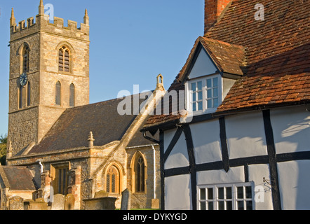 La chiesa del villaggio medievale e metà in legno con travi di legno bianco e nero cottages nel Warwickshire villaggio di Welford on Avon. Foto Stock