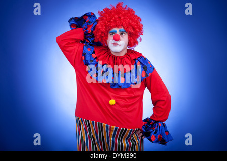 Sorpreso clown uomini su sfondo blu. Riprese in studio Foto Stock