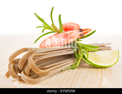 Gamberetti con le tagliatelle fresche ed erbe su sfondo bianco. Deliziosi frutti di mare. Foto Stock