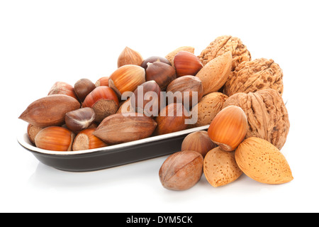 Vari dadi, noci, nocciole, mandorle e castagne nella ciotola nero isolato su sfondo bianco. Stagionale dadi sani. Foto Stock