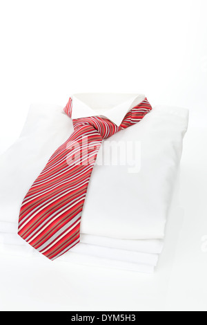 Pila di business bianco Shirt con strisce rosse cravatta su sfondo bianco. Moderno concetto di business. Foto Stock