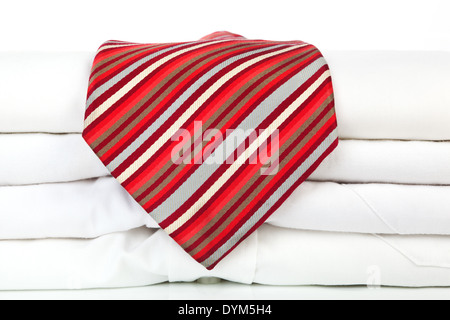 Pila di business bianco Shirt con strisce rosse cravatta su sfondo bianco. Moderno concetto di business. Foto Stock