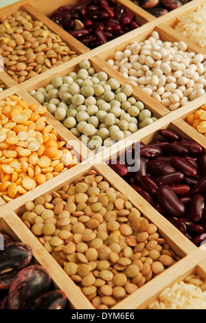 Variazione di diversi i fagioli, le lenticchie e i piselli in scatola di legno. Foto Stock