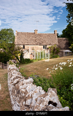 Cotswold cottage in pietra con parete e giardino in estate Foto Stock