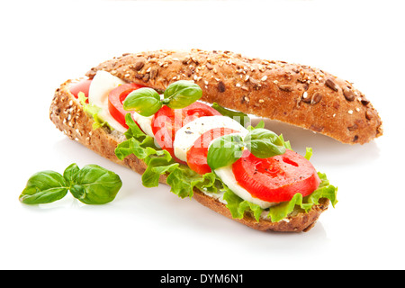 Baguette con verdure fresche, pomodoro, basilico e mozzarella su sfondo bianco. Sandwich caprese. Foto Stock