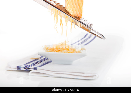 Shredded formaggio Gouda nella ciotola bianco su bianco asciugamano isolati su sfondo bianco. Foto Stock