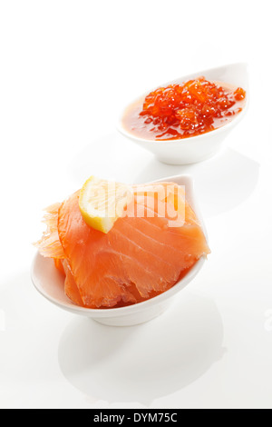 Salmone affumicato e caviale rosso in bianco bocce isolati su sfondo bianco. Culinario concetto di frutti di mare. Foto Stock