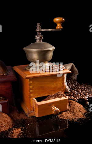 Il caffè ancora in vita. Macinino da caffè, caffè e caffè in grani isolati su sfondo nero. Lussuoso caffè vintage. Foto Stock
