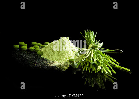 Sana integratori di verde. Spirulina, wheatgrass, giovane appena, clorella sa terra, pillole di verde e fresco wheatgrass isolato Foto Stock