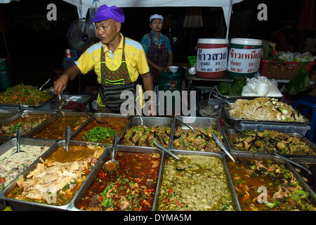 Uomo di vendita specialità tailandesi, il Mercato Notturno in strada pedonale, Chiang Rai, provincia di Chiang Rai, Thailandia del Nord della Thailandia Foto Stock