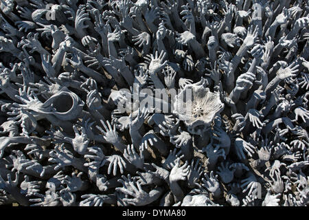 Rappresentazione dell'inferno, mani supplicanti per aiutare a Wat Rong Khun, bridge all'ingresso del tempio bianco, dall'architetto Foto Stock