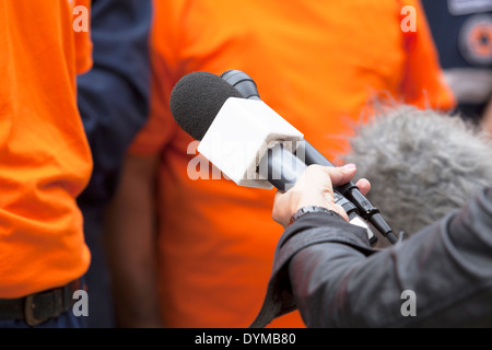 Un giornalista sta facendo un colloquio con un microfono Foto Stock