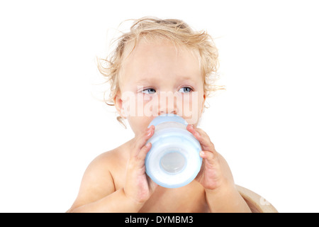 Carino blonde curly bambina bere latte da bambino battaglia isolati su sfondo bianco. Baby, latte e mangiare con il concetto di copia Foto Stock